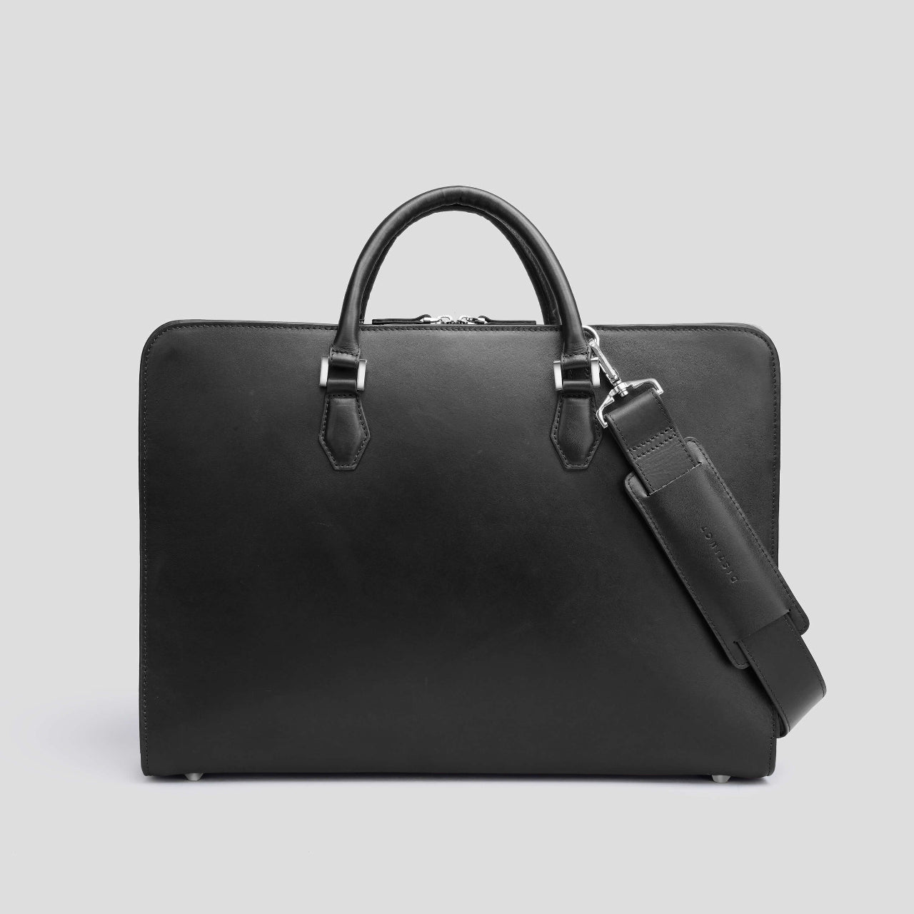 Black leather briefcase from the brand DISTINCT with a shoulder strap on a light gray background